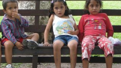 a little girl sitting on a bench