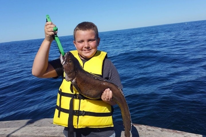 a man standing next to a body of water