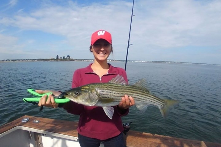 a person holding a fish on a boat in a body of water