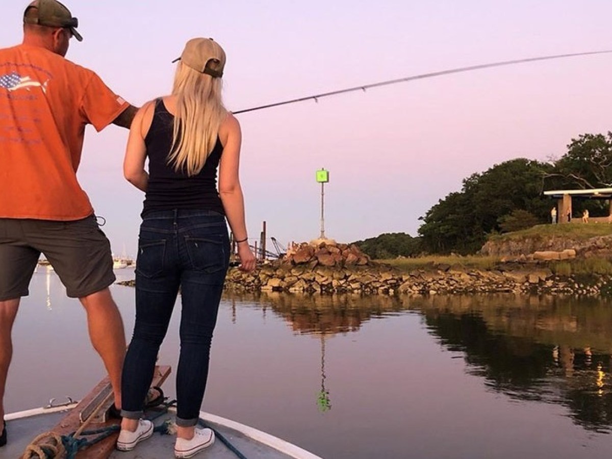 a man standing next to a body of water