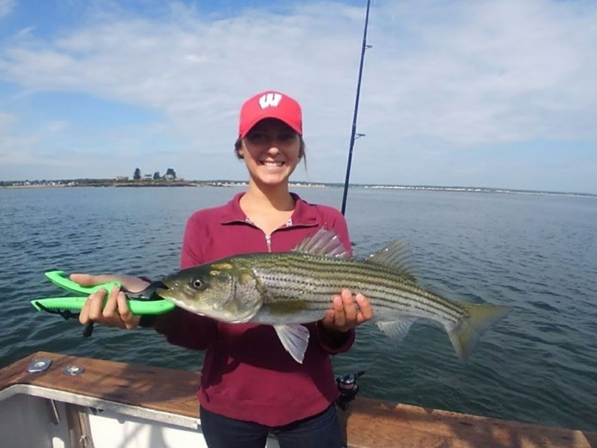 a person holding a fish on a boat in a body of water