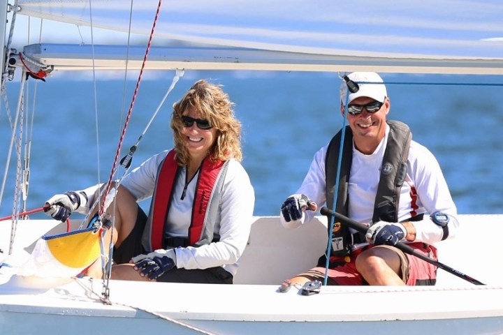 a man and a woman riding on the back of a boat