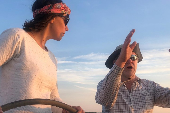 a man standing next to a body of water