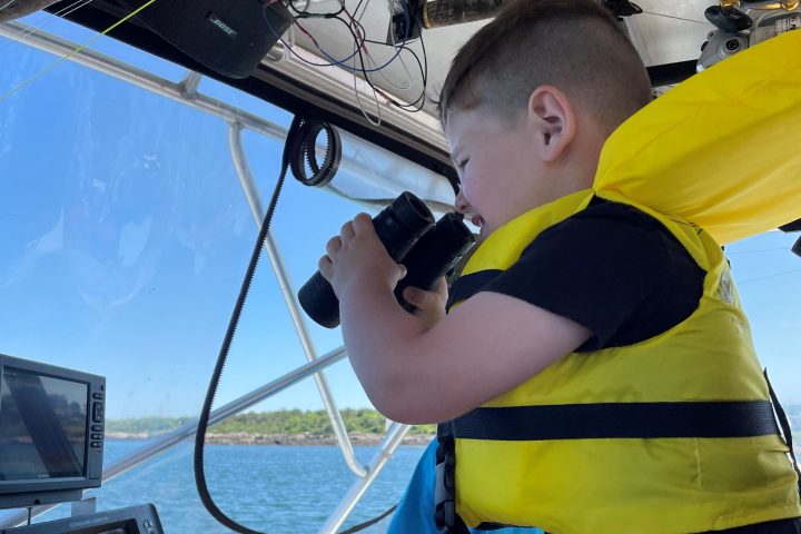 a man holding a hot dog on a boat