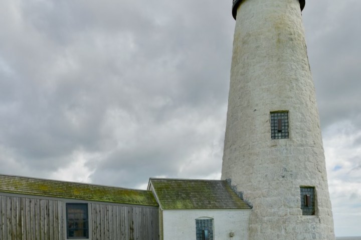 a large stone building with a grassy field