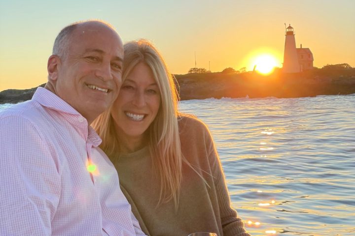 a man and woman sitting next to a body of water