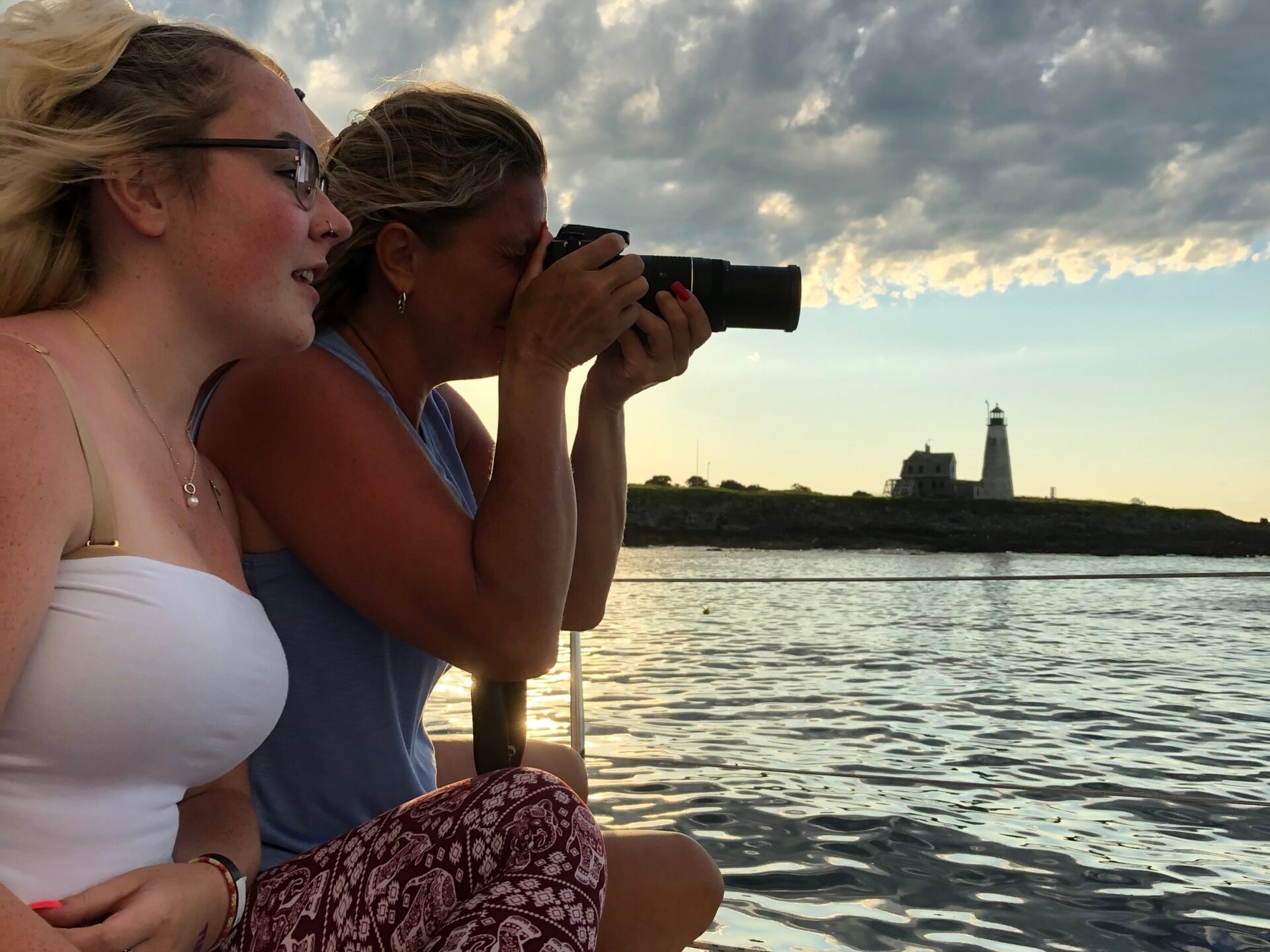 a woman sitting next to a body of water