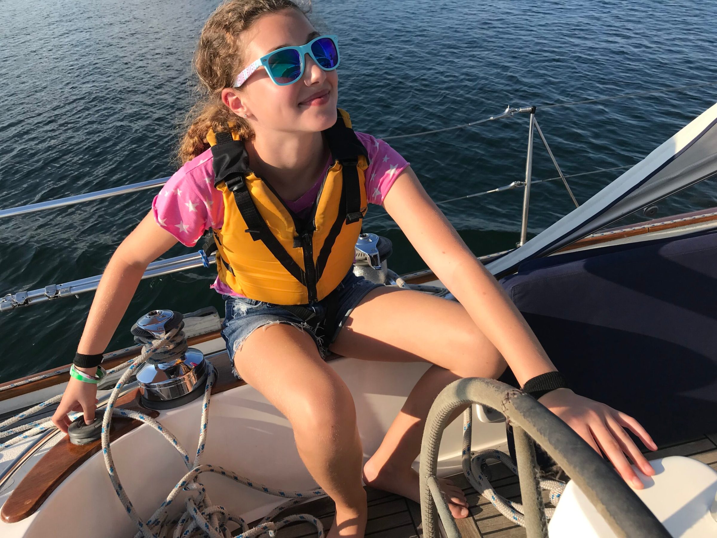 a woman in sunglasses sitting in a boat on the water