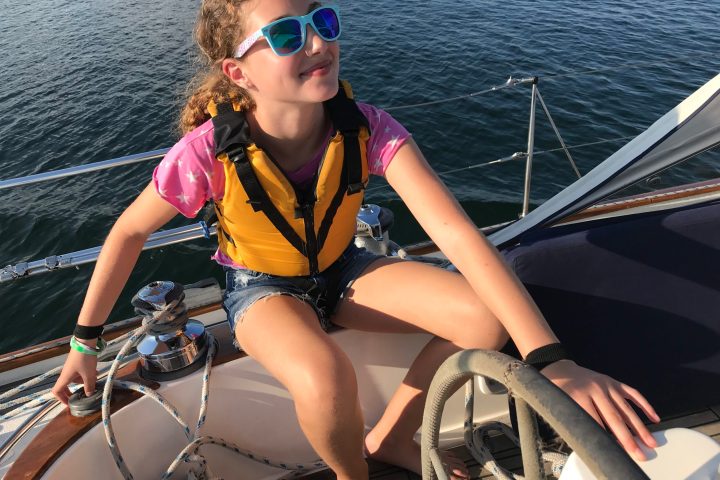 a woman in sunglasses sitting in a boat on the water
