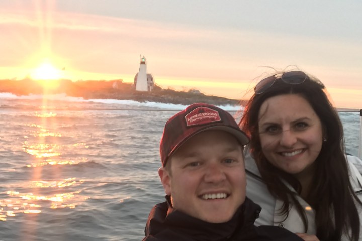 a woman smiling next to a body of water