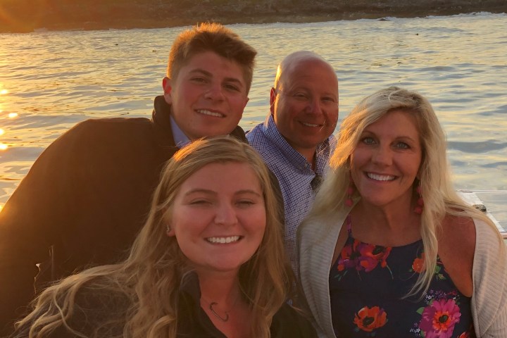 Regina Hopper et al. posing in front of a body of water