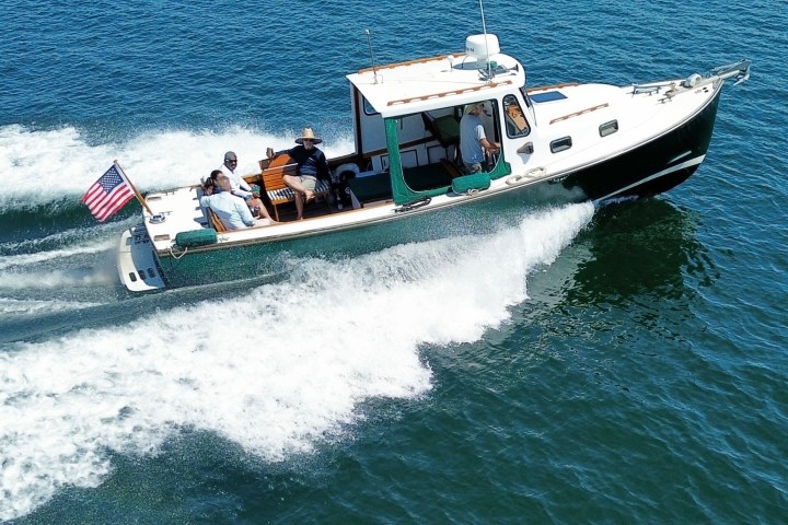 a group of people riding on the back of a boat in the water