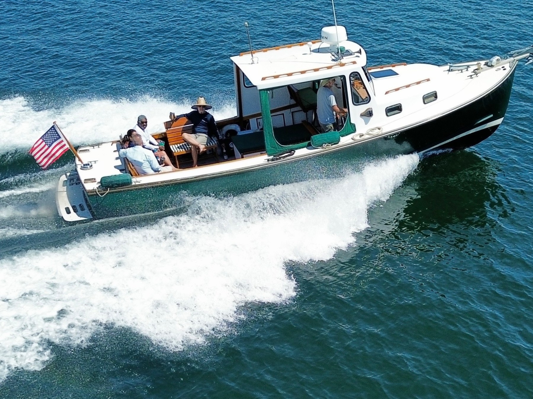 a group of people riding on the back of a boat in the water